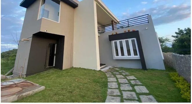 Completed modern home with landscaped stepping-stone path in Kasam, Katpadi built by Gravitas Builders
